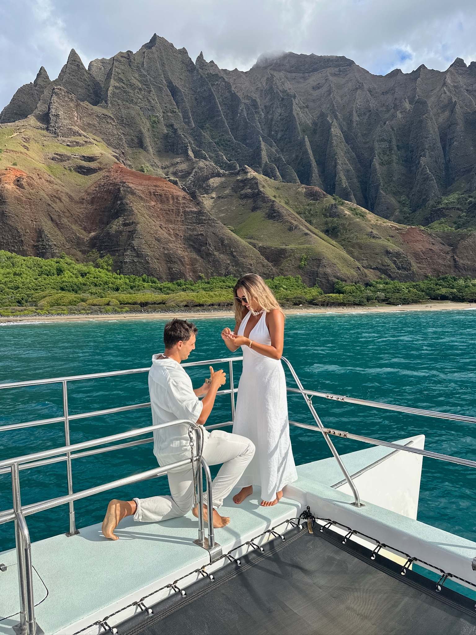 Tanner Shae kneels and proposes to Emma Jenny on a boat during their vacation in Hawai’i.